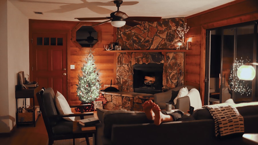 wood-panelled cabin living room with a stone fireplace and a lit Christmas tree, warm and lived-in