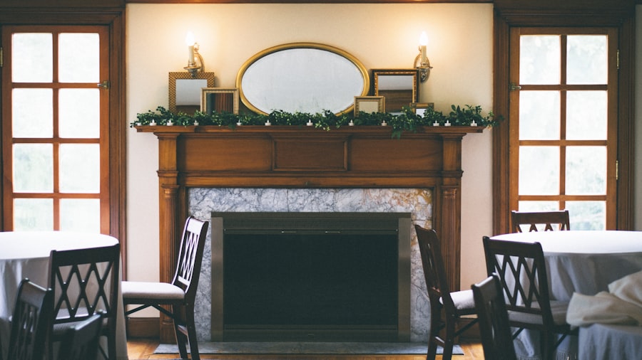 symmetrical fireplace with green garland across a dark wood mantel, framed by two tall windows