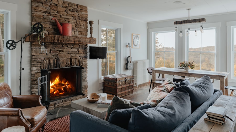 lit stone fireplace beside a deep blue velvet sofa in a bright, neutral living room