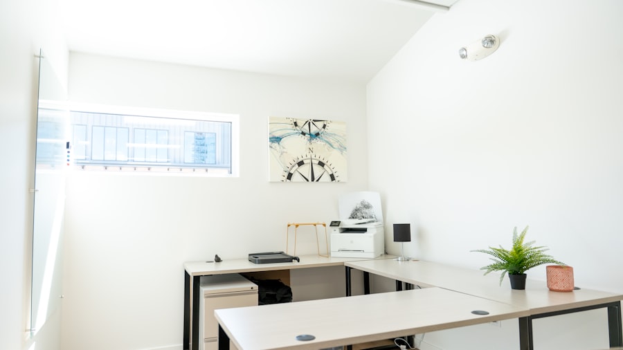 compact home office with a white desk, a laptop, and a window overlooking the city